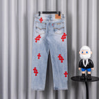 Light blue denim pants with red cross appliques on front, button fly