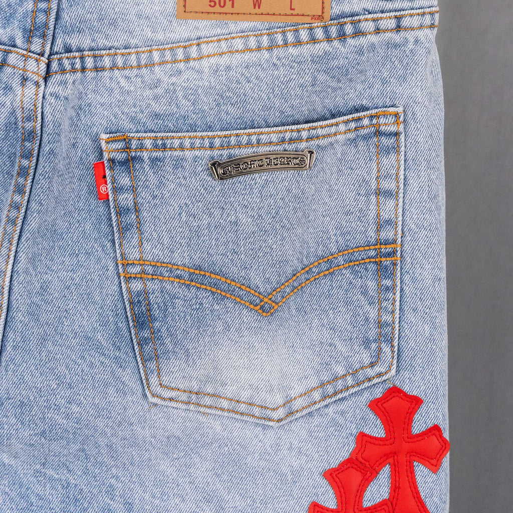 Light blue denim pants with stitched back yoke panel and red cross applique