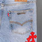 Light blue denim pants with stitched back yoke panel and red cross applique