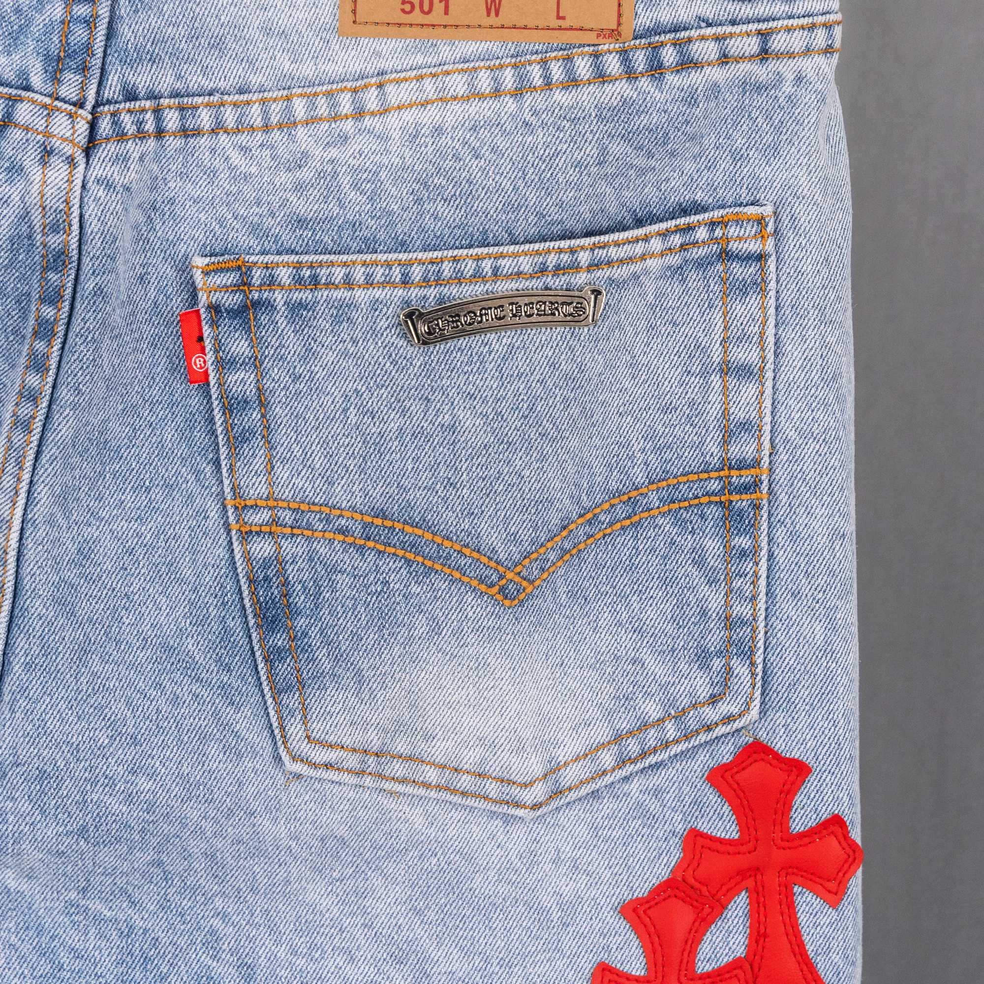 Light blue denim pants with stitched back yoke panel and red cross applique