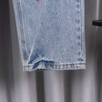 Light blue denim pants with folded hem and orange contrast topstitching
