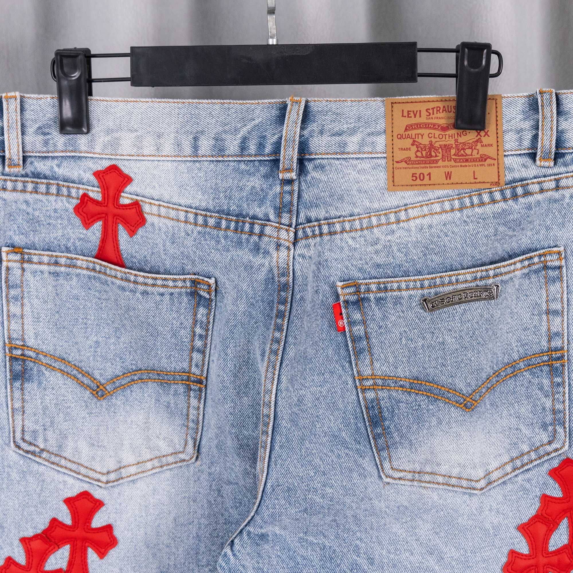 Light blue denim pants with red cross on pockets and metal logo patch