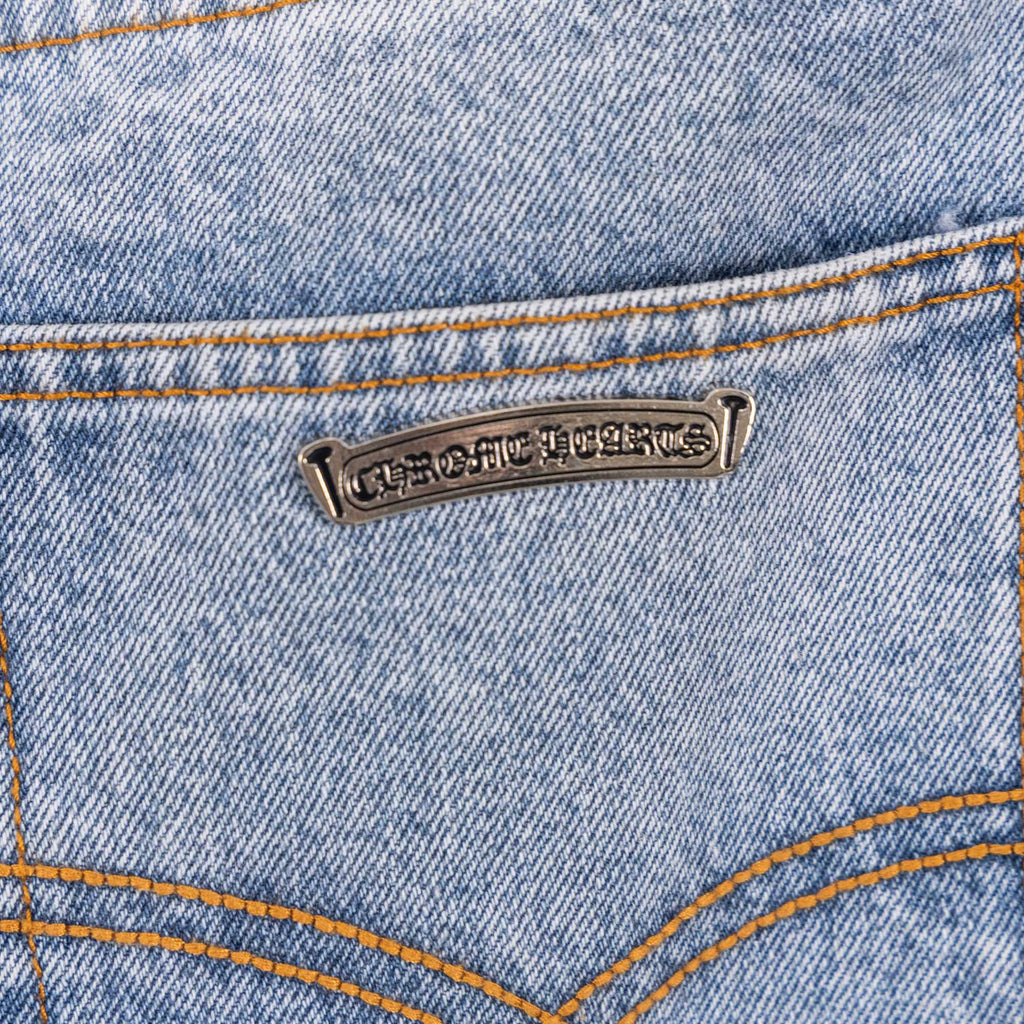 Light blue denim pants with metal logo patch and orange contrast topstitch