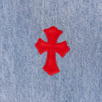 Light blue denim pants with large red cross applique on leg