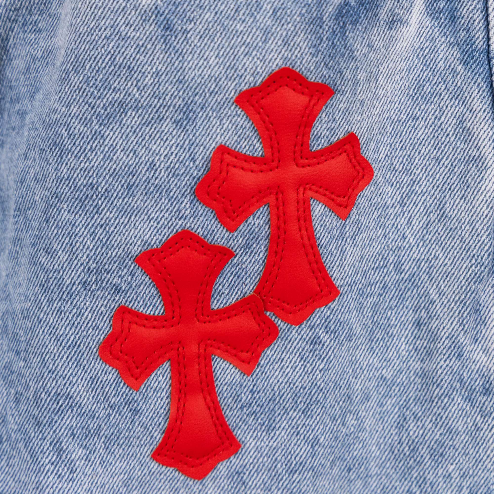 Light blue denim pants with three red cross appliques on upper leg