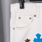 White pants with button fly and small leopard-and-blue cross detail, front close-up