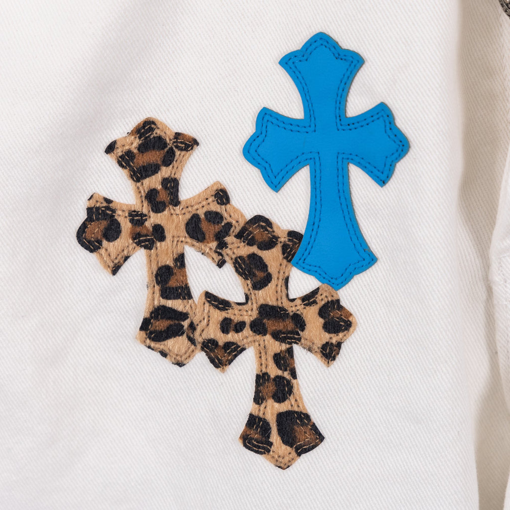 White pants fabric with blue cross and leopard cross applique patch, close-up