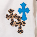 White pants fabric with blue cross and leopard cross applique patch, close-up