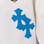 White pants with large blue cross applique graphic on fabric, close-up
