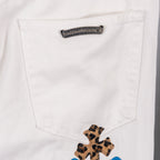 White jeans pocket with small leopard cross applique near seam, close-up
