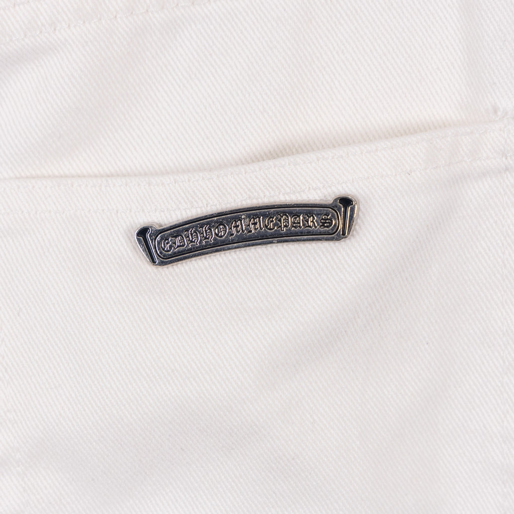 Pants metal logo bar on white denim near belt loop