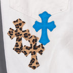 Chrome pants with leopard print cross patch and blue cross appliques on white denim