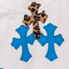Pants with leopard print cross applique and three blue cross patches on white denim