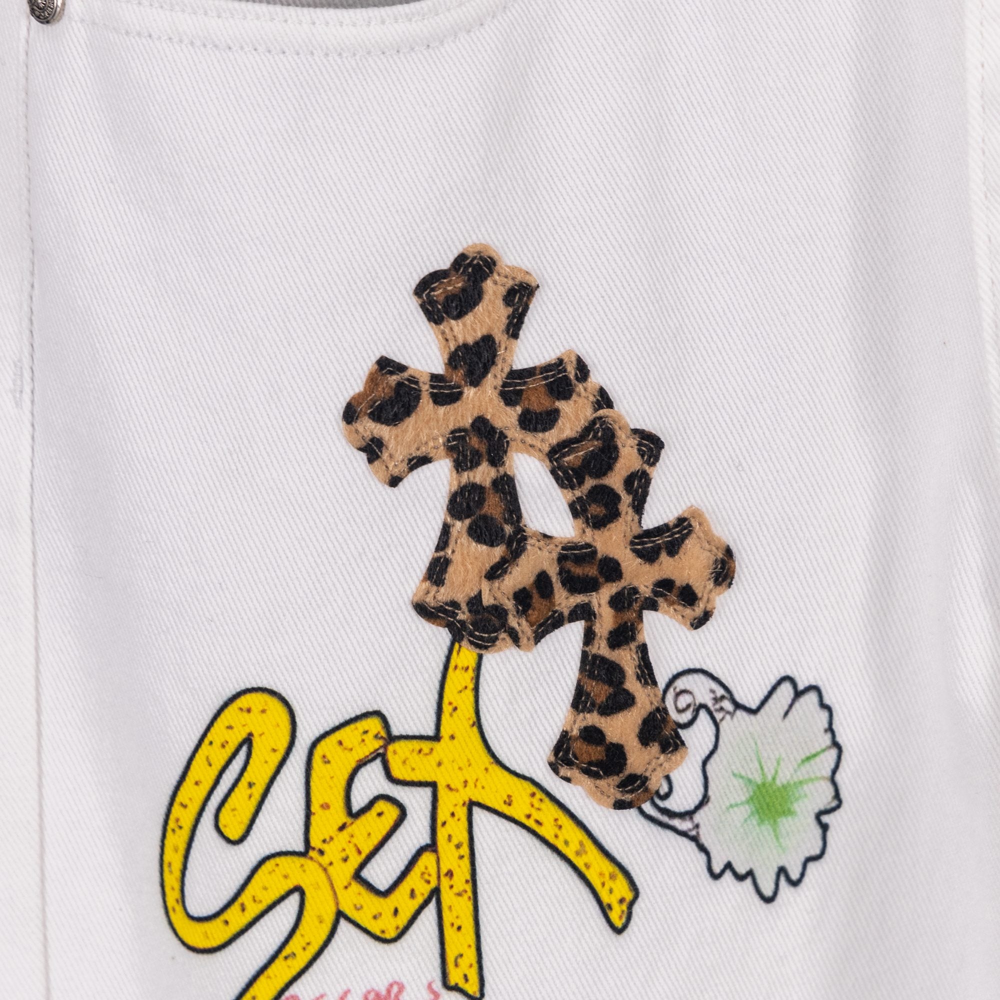 Embroidered leopard cross patch with colorful graffiti-style text on white denim