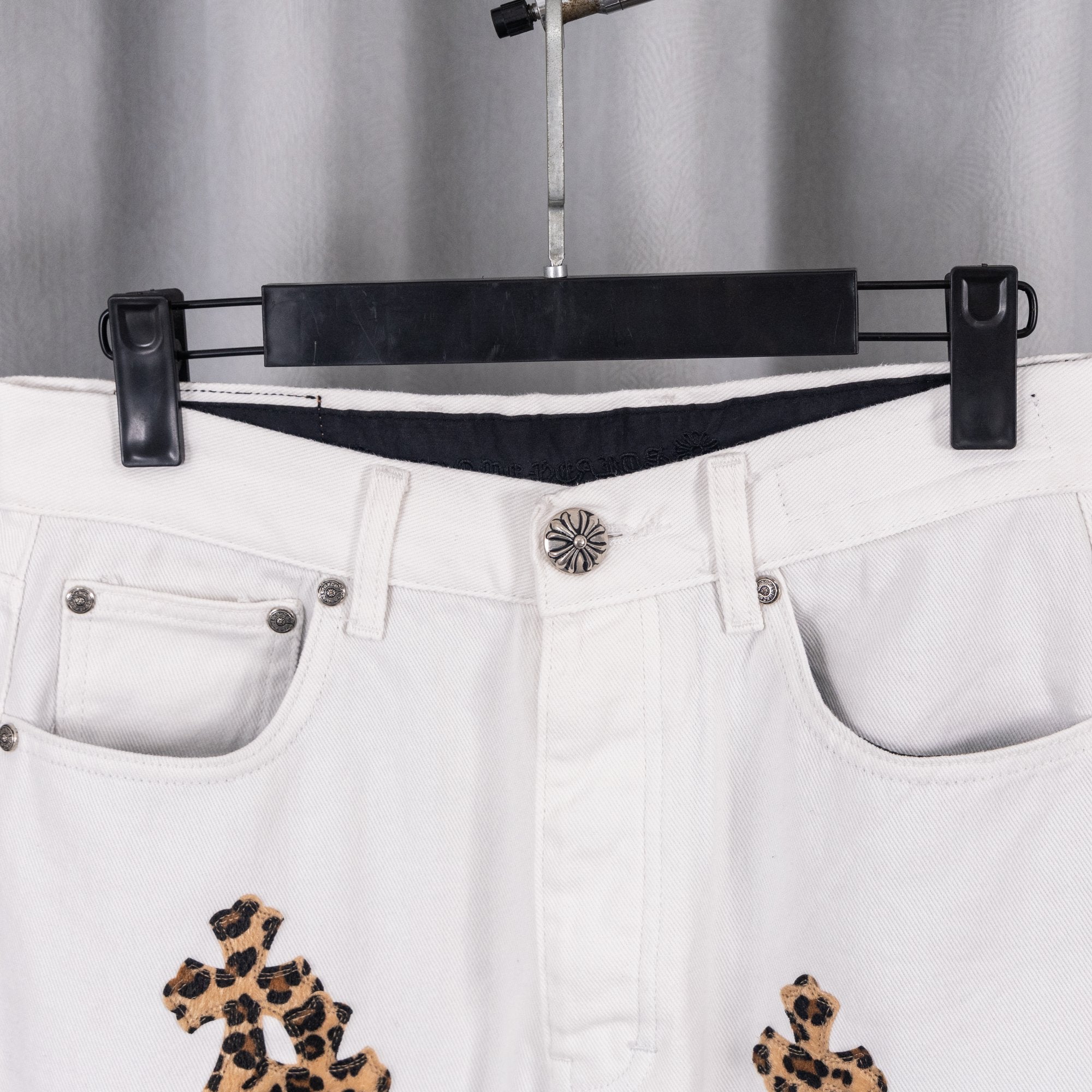 White denim pants waistband with silver button and leopard cross embroidery