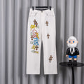 White denim pants with colorful graphic text and small cross patches