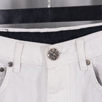 White denim pants waistband with decorative metal button and hidden button detail