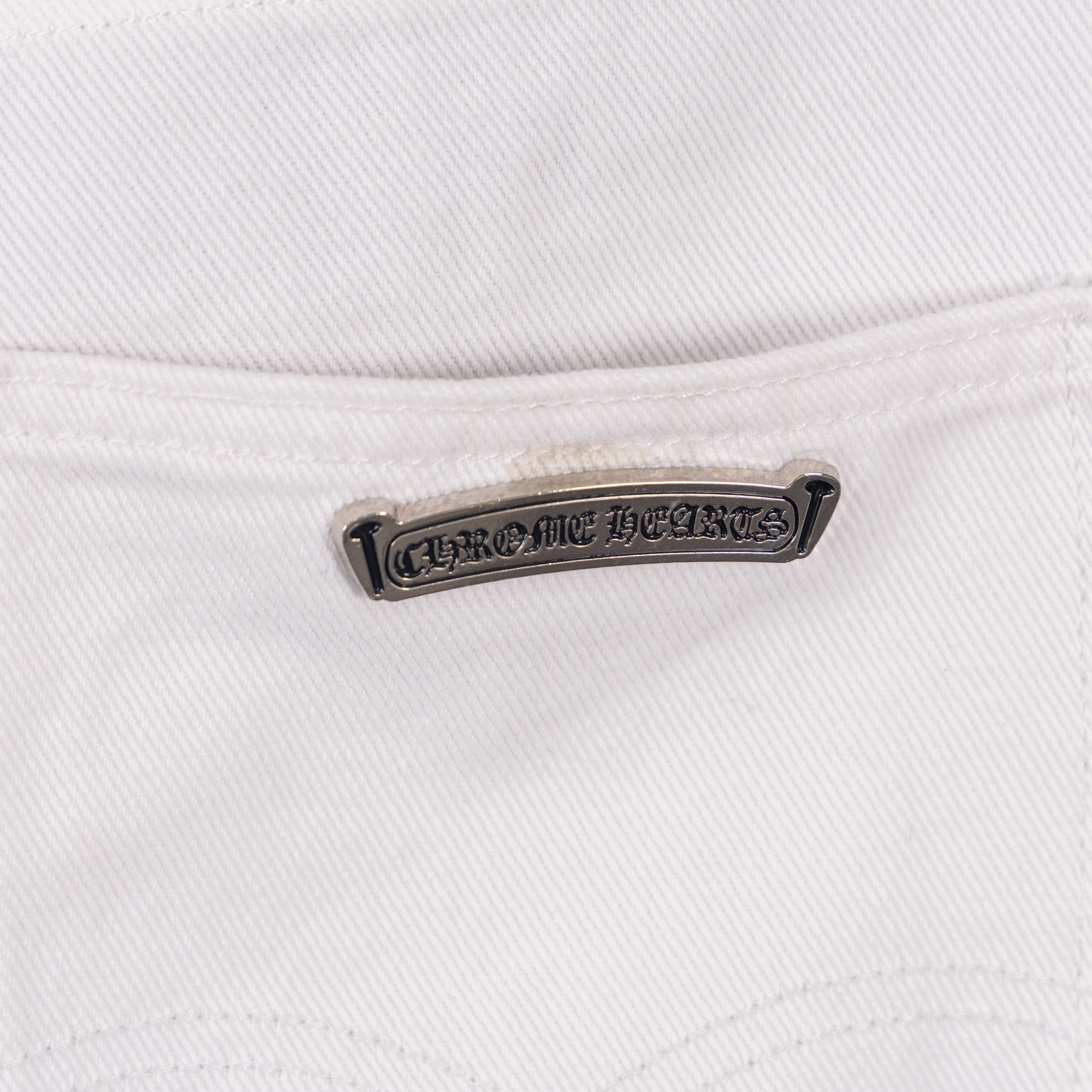 White denim pants with chrome logo metal tag detail