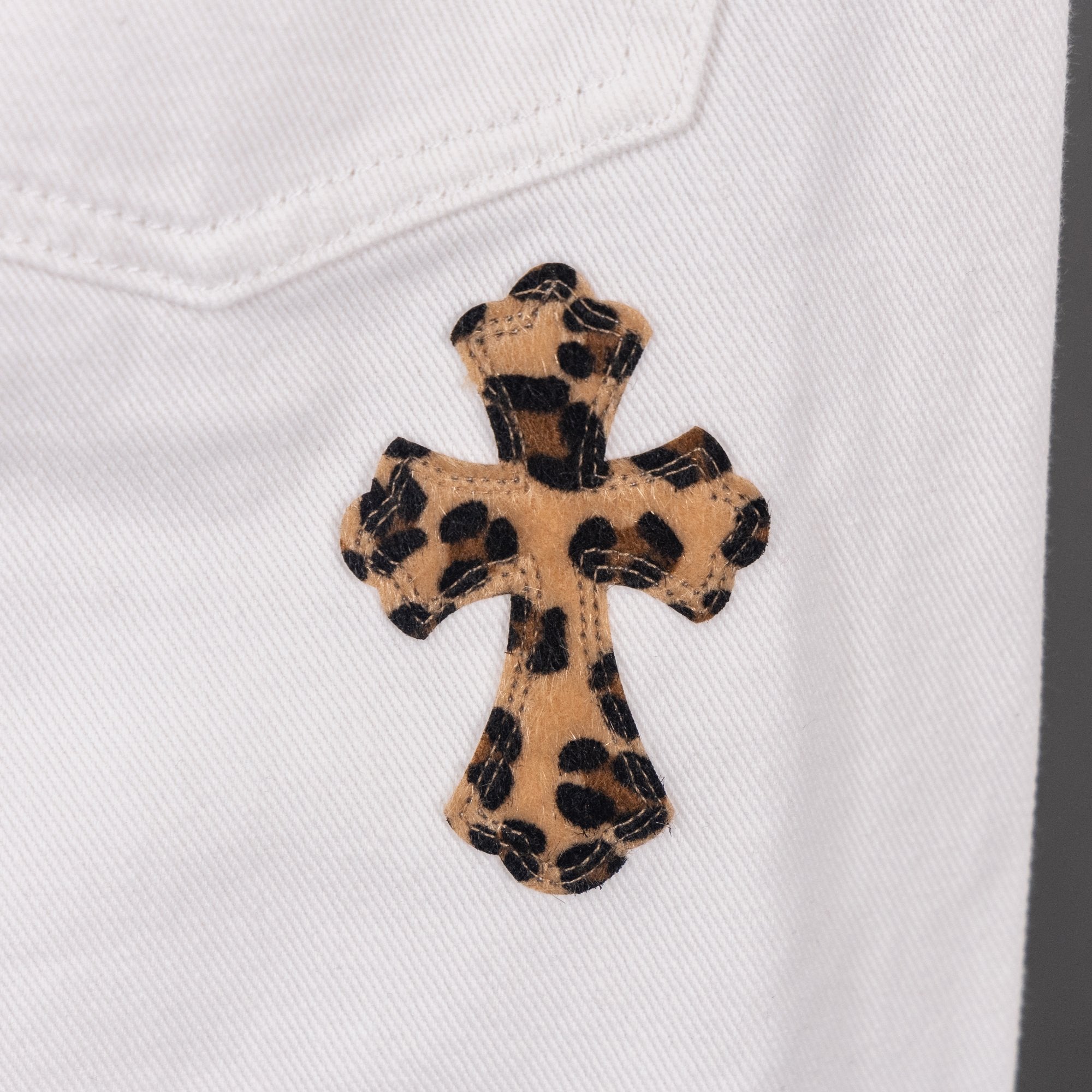 White pants with leopard cross appliqué on front