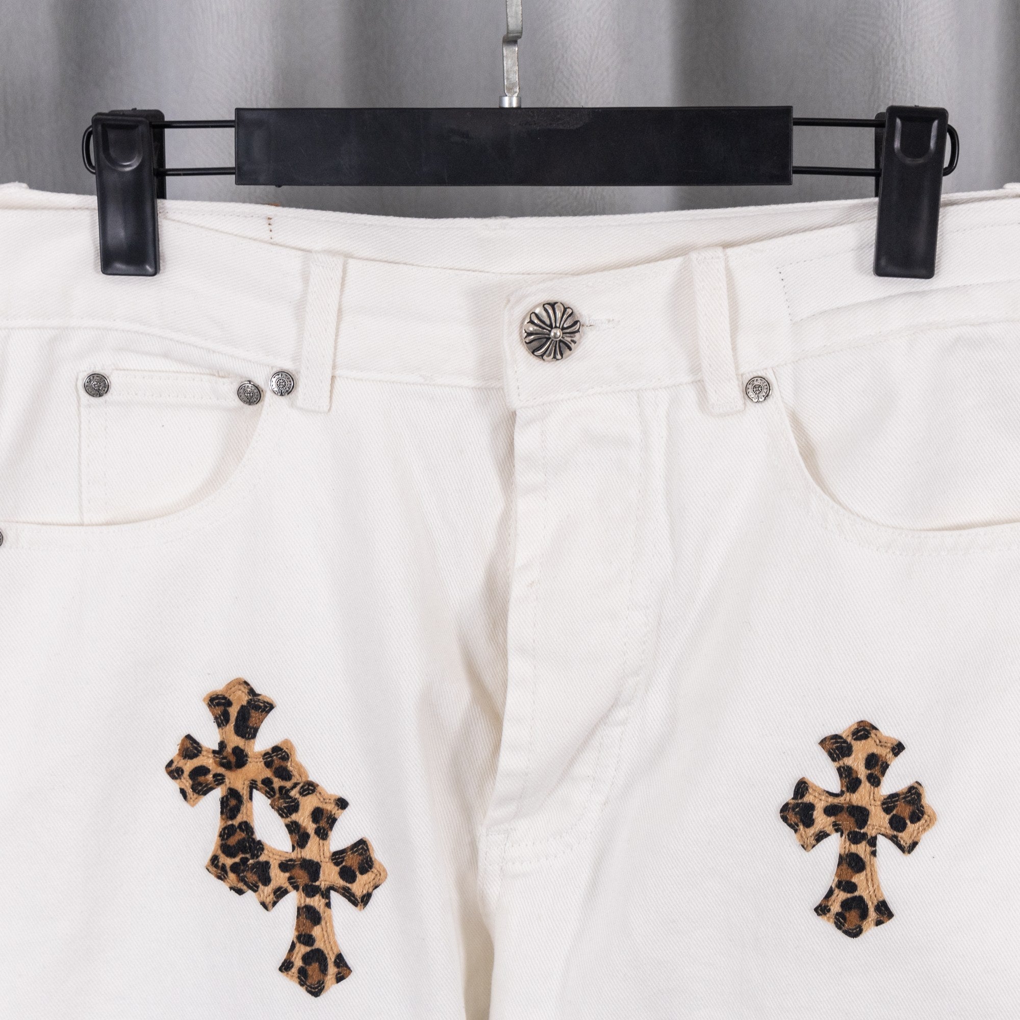 White denim pants with button waistband and leopard cross embroidery
