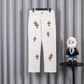 White denim pants with leopard cross patches and button fly