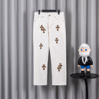 White denim pants with leopard cross patches and button fly