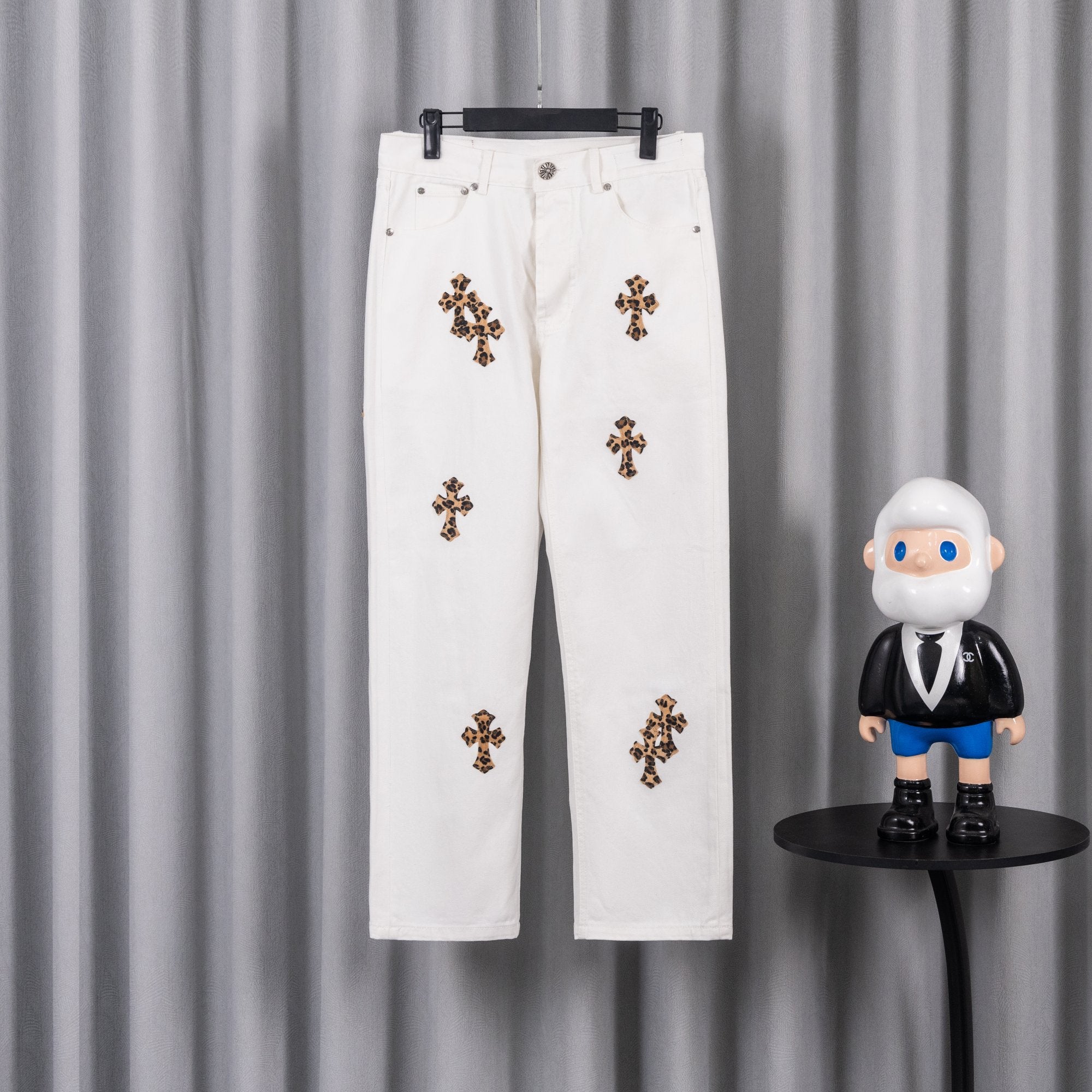 White denim pants with leopard cross patches and button fly