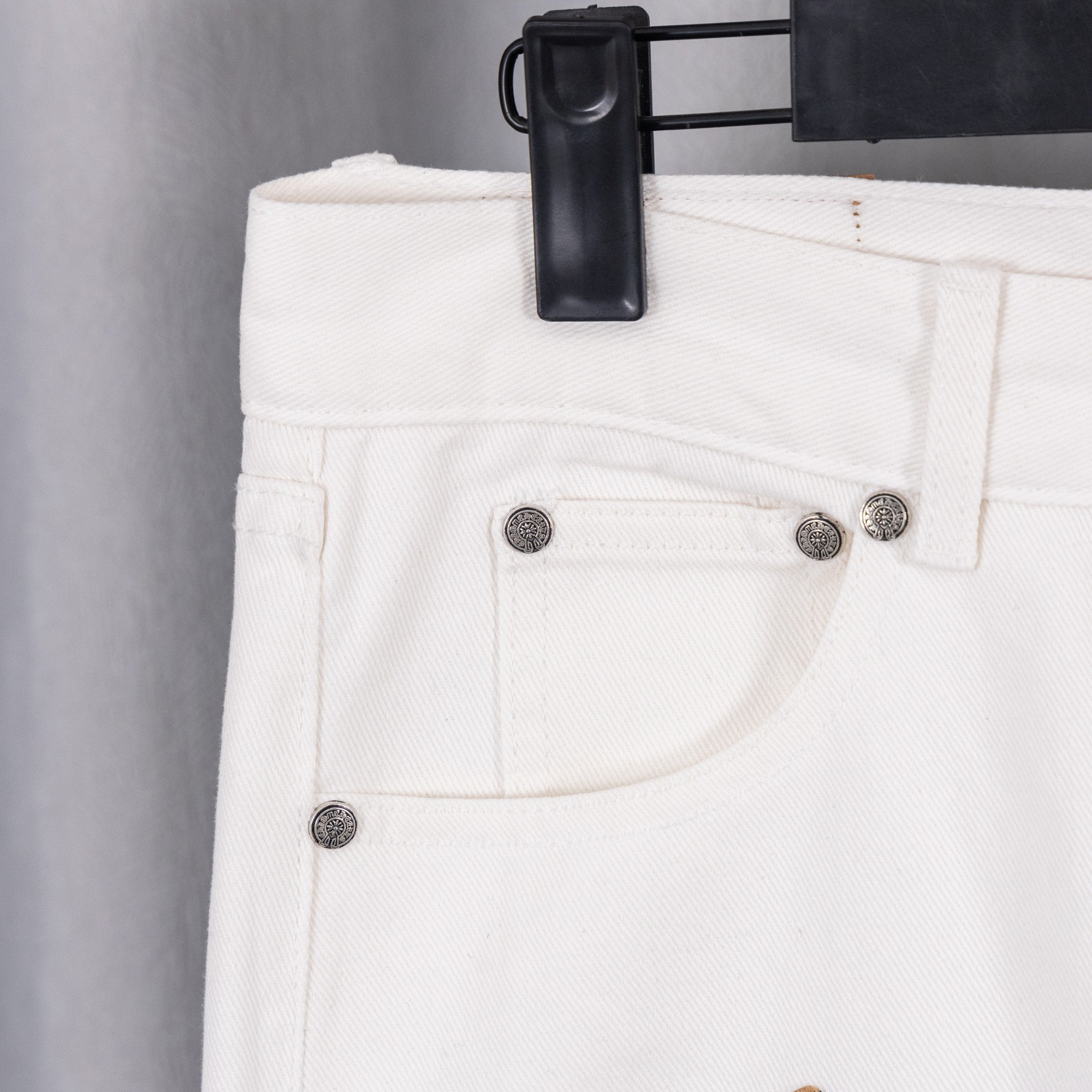 White denim pants with metal button closure and slanted front pockets