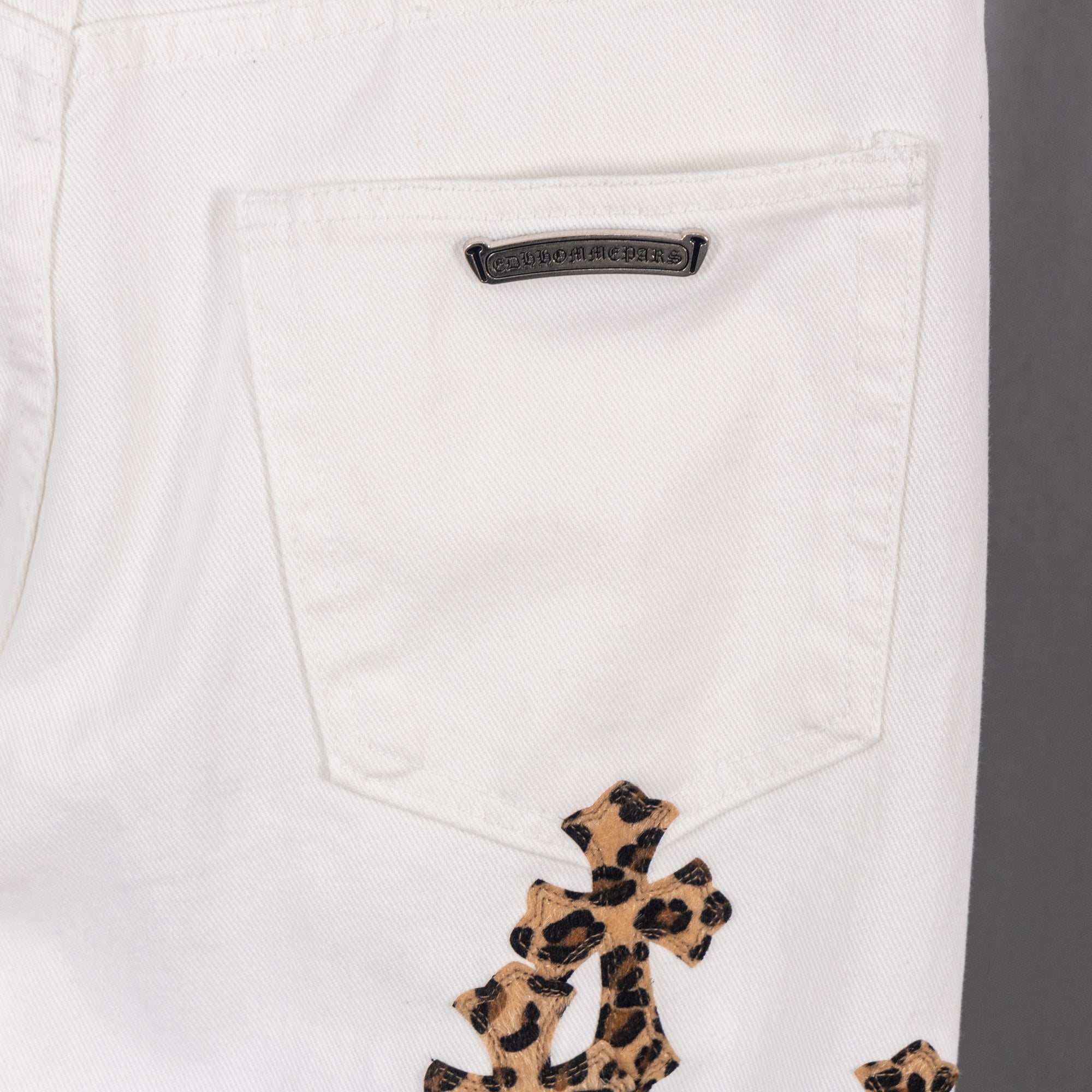 White denim pants pocket with logo patch and leopard cross embroidery