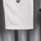 White denim pants with leopard cross patch near hem