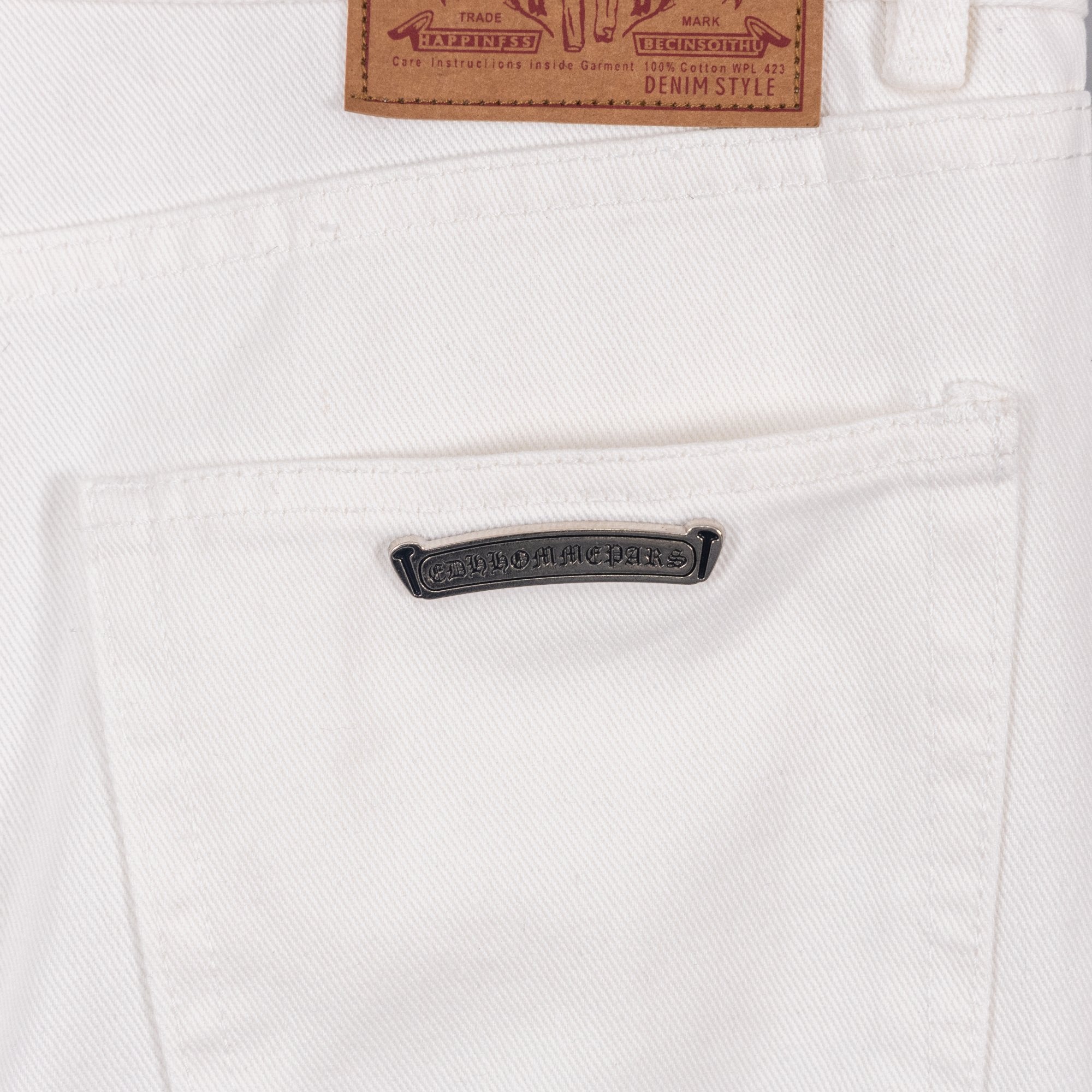 White denim pants with black logo patch and leather waist label