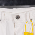 White denim pants with metal button and yellow brand tag, close-up
