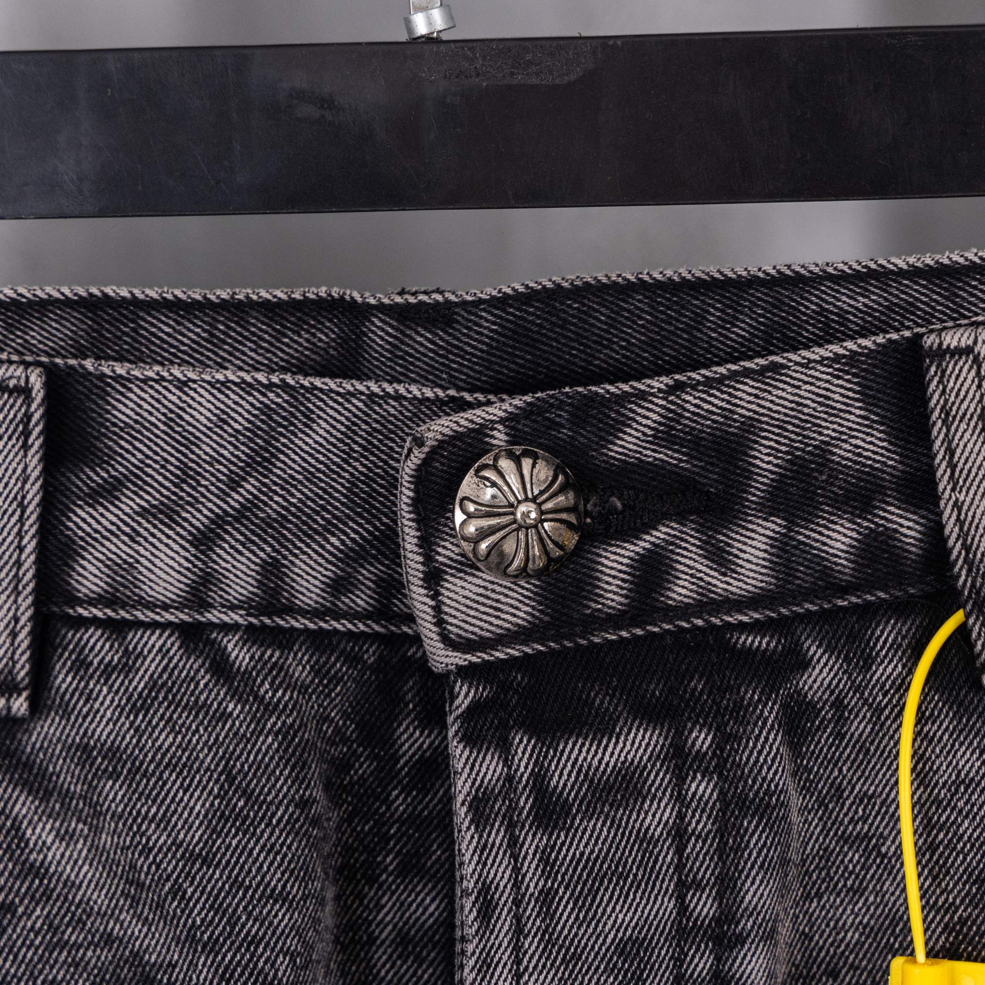 Dark gray denim jeans with metal button and stitched pocket detail