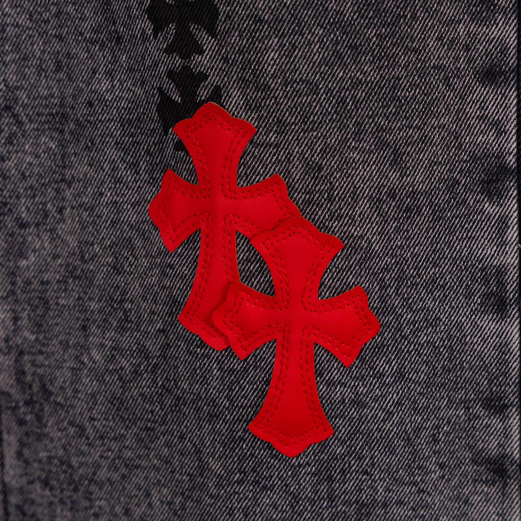 Black denim pants with red and black cross patches