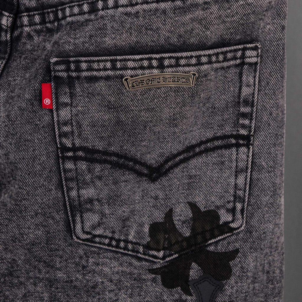 Dark gray denim jeans with stitched waistband pocket and black floral applique