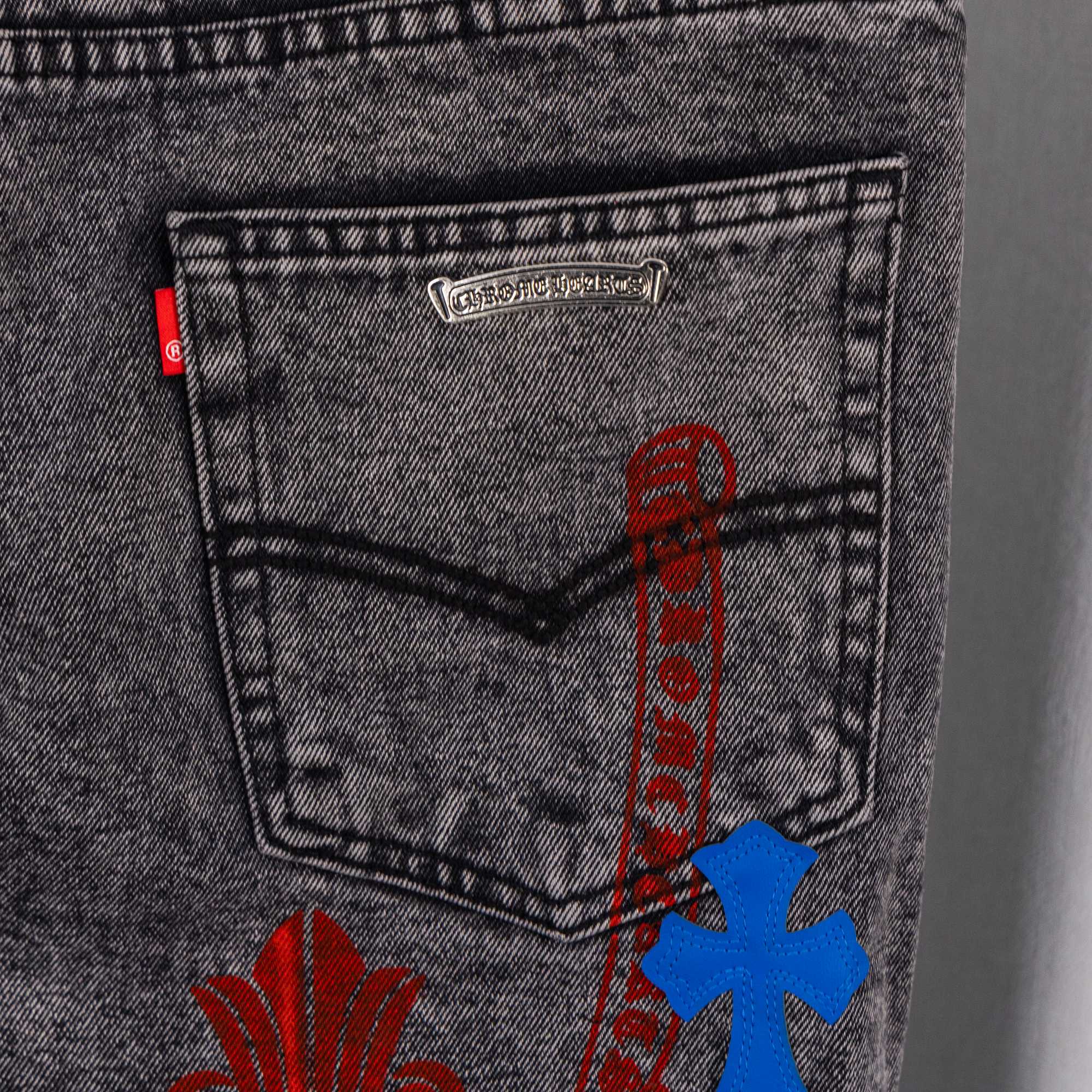 Dark denim pants pocket label with blue cross applique