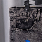 Dark gray denim pants pocket area with metal buttons and stitched seams