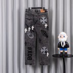 Dark wash denim pants with large patch graphics on front, straight legs