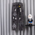 Dark wash denim pants with cross-and-flower patches, front view