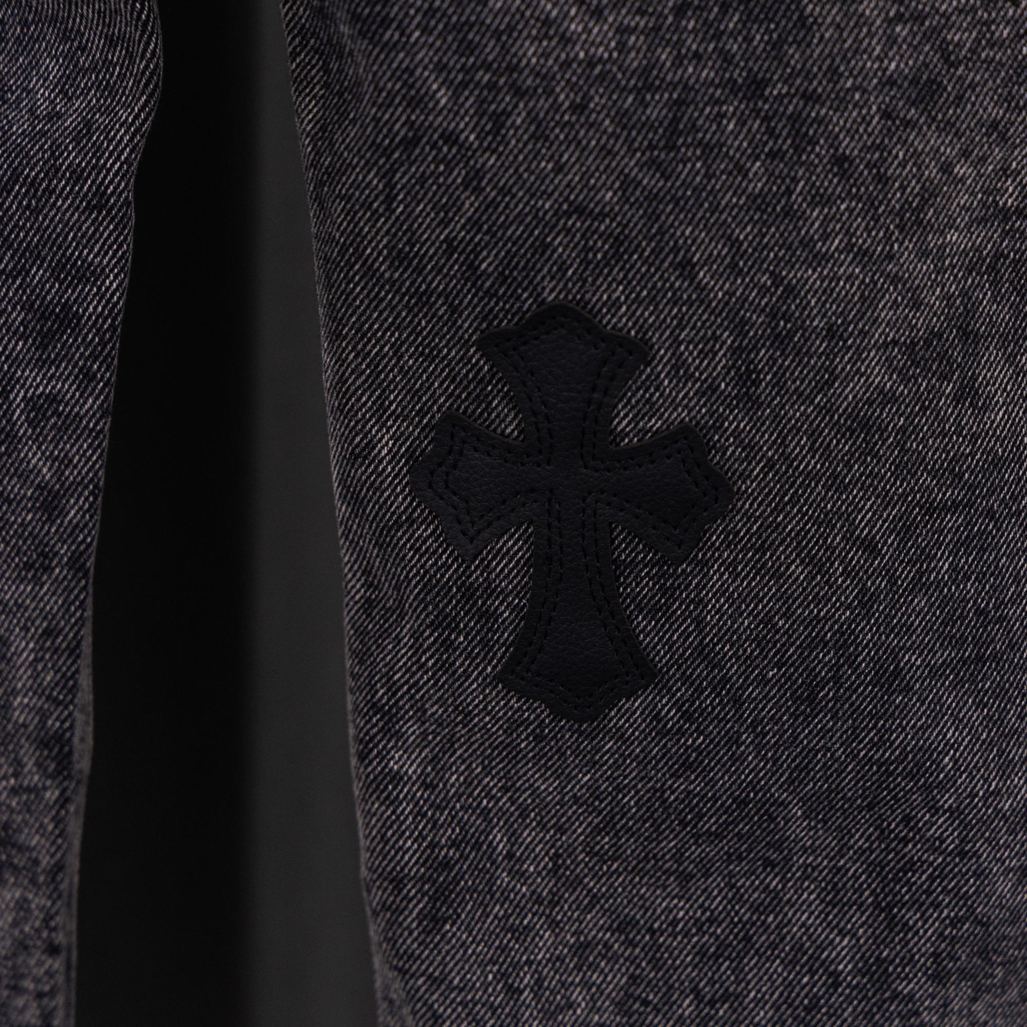 Denim fabric close-up with black cross patch