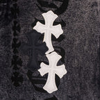 Dark denim pants close-up of white and black cross patch design