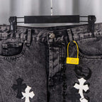 Black denim pants with belt loops, button fly, and contrasting cross applique patches