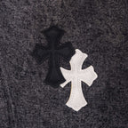 Cross-shaped applique patch on dark denim pants in black and white