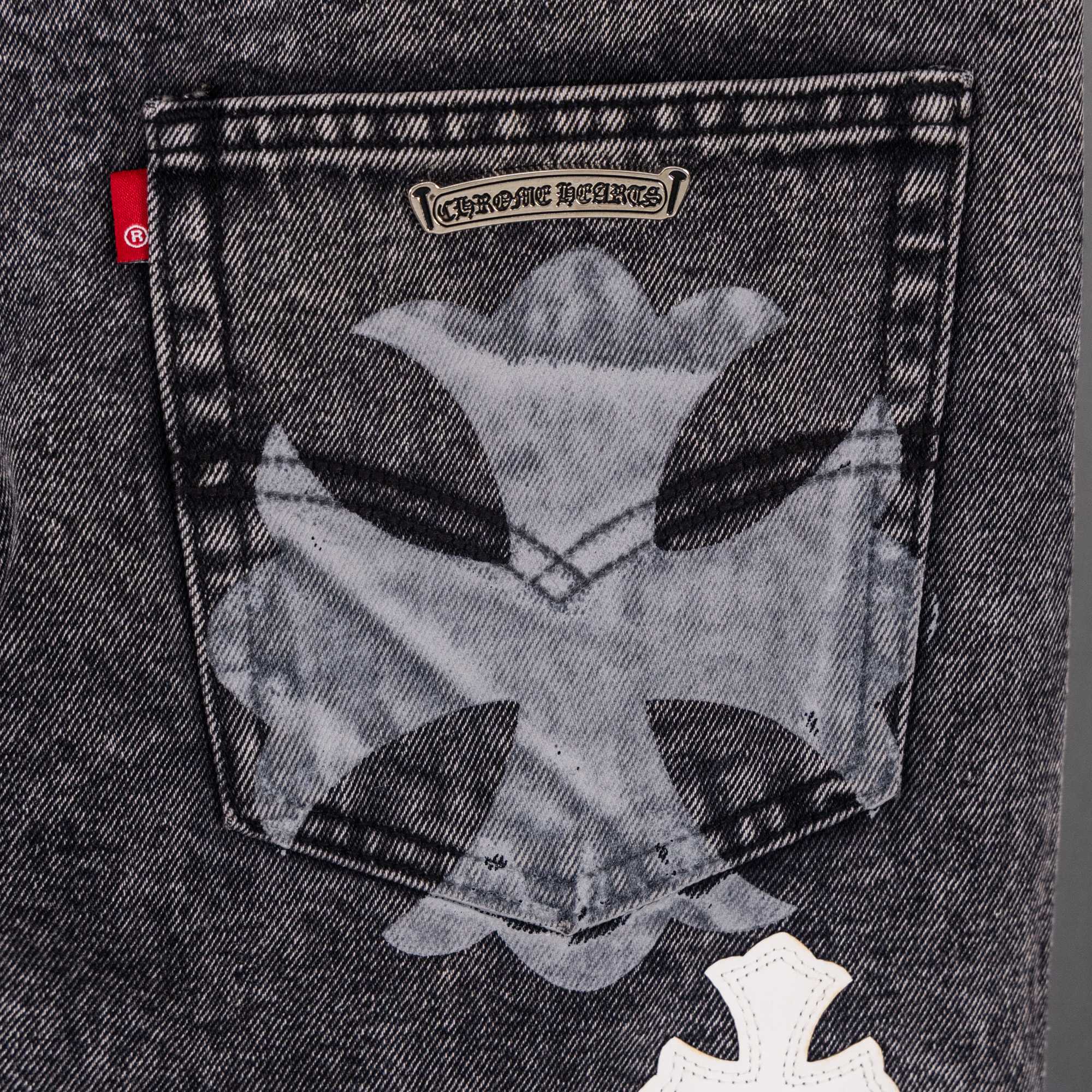 Dark denim pants with large pocket graphic and cross patch