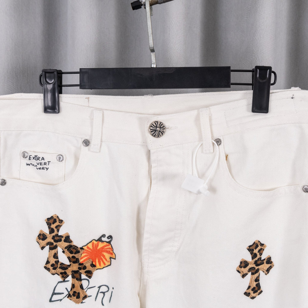White pants with front cross embroidery and logo patch on left pocket