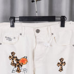 White pants with front cross embroidery and logo patch on left pocket