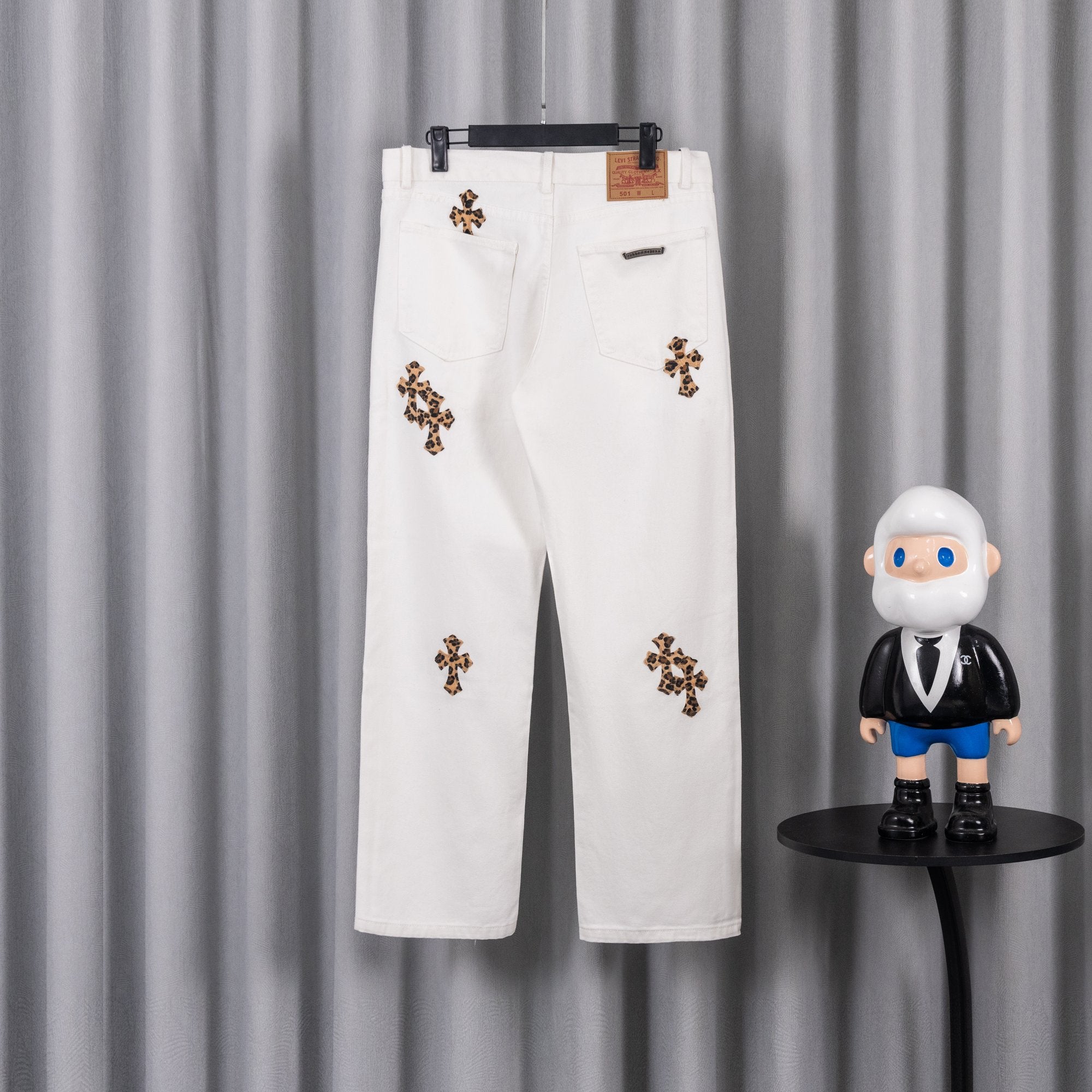 White pants with leopard-print cross patch details and back-pocket design