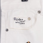 White pants with “Extra Vert Very” label and round button details