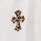 White pants with small leopard-print cross patch on the leg
