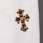 White pants with small leopard-print cross patch on the leg